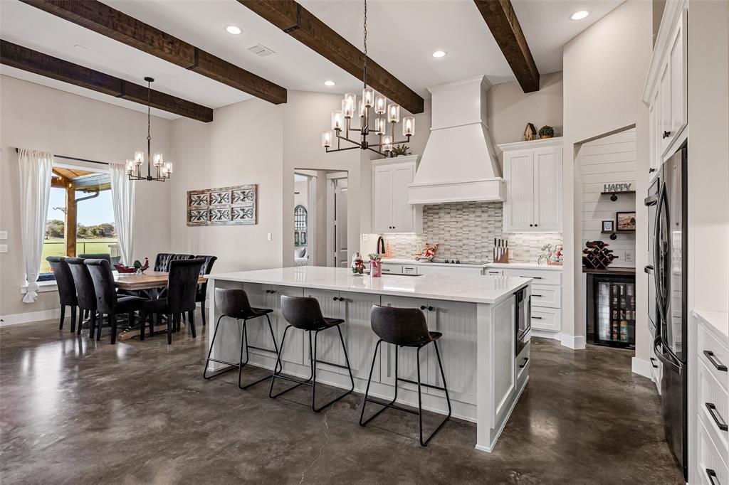 310 Runyan Rnch Road Tolar, TX 76476 - Photo 11 of 35 Kitchen with a chandelier, concrete floors, backsplash, beam ceiling, and recessed lighting