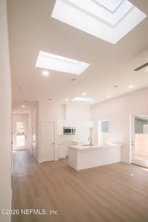 a view of a kitchen with kitchen island a sink stainless steel appliances and cabinets