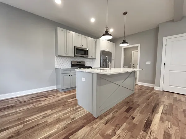 a kitchen with kitchen island a sink stainless steel appliances and cabinets