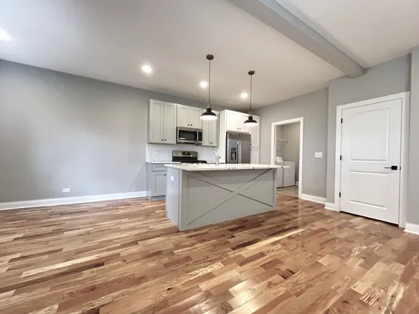 a large kitchen with kitchen island a sink stainless steel appliances and cabinets