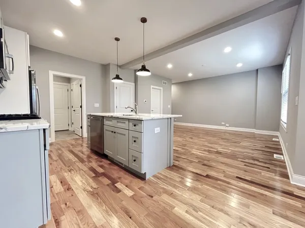 a large kitchen with a lot of cabinets and wooden floor