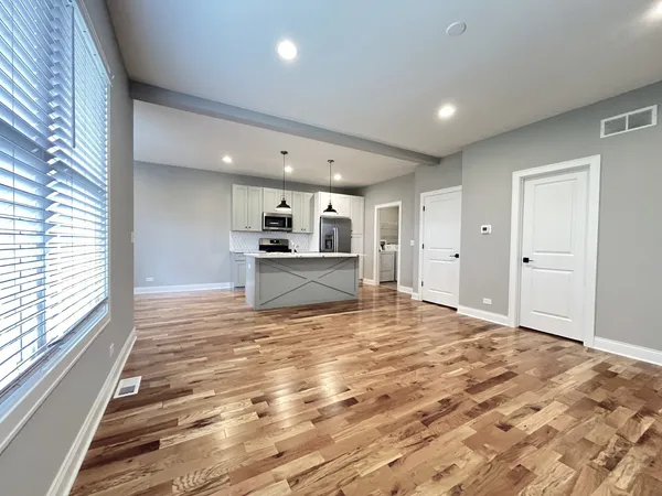 a view of empty room with wooden floor and window