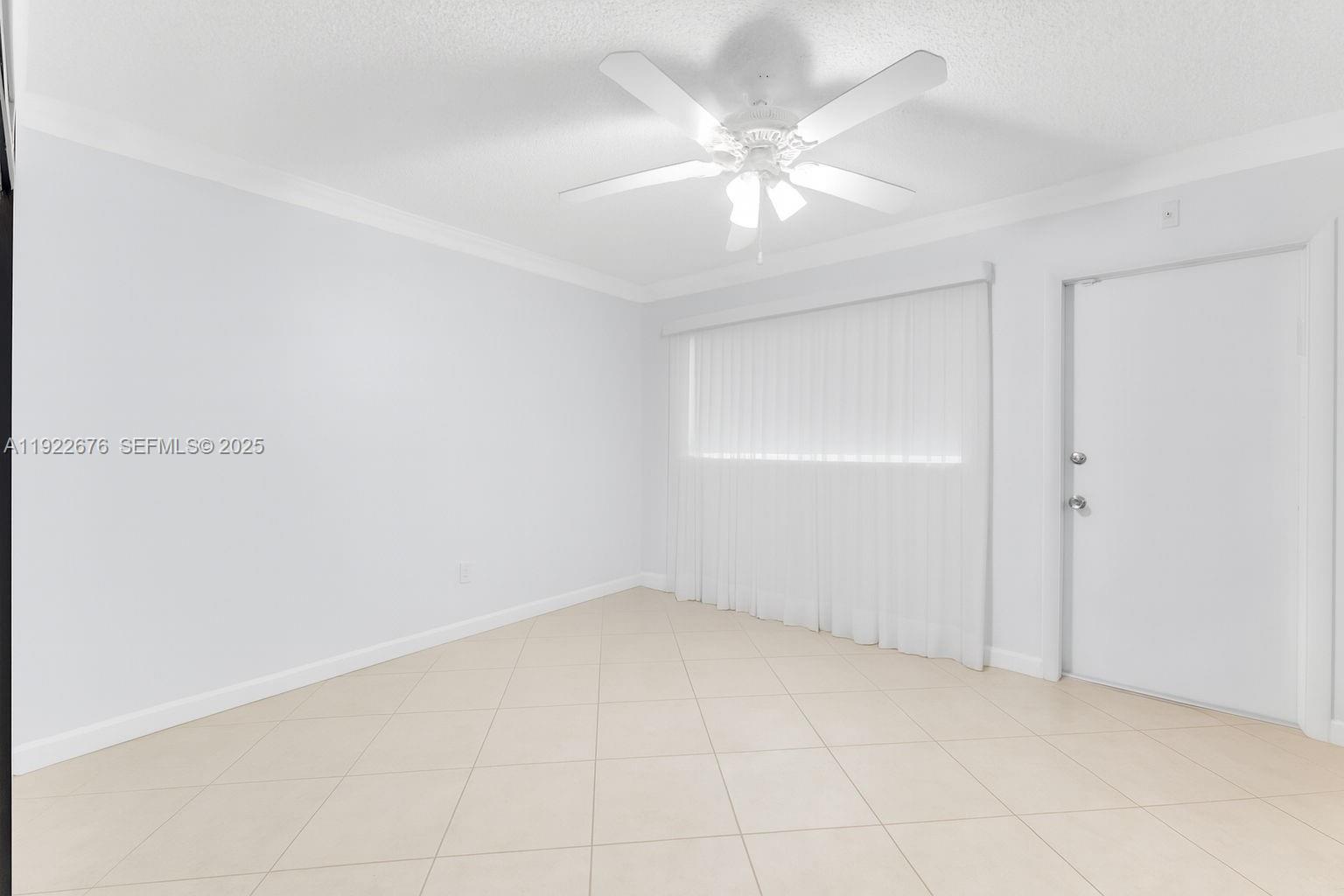 900 Atlantic Shores Boulevard, Unit 105 Hallandale Beach, FL 33009 - Photo 12 of 22 an empty room with a chandelier fan and windows