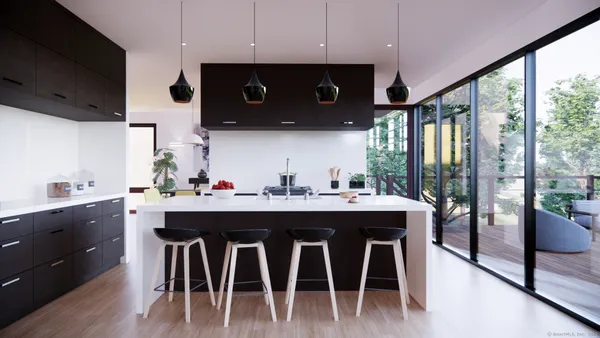 a kitchen with stainless steel appliances granite countertop a stove a refrigerator a sink and white cabinets with wooden floor