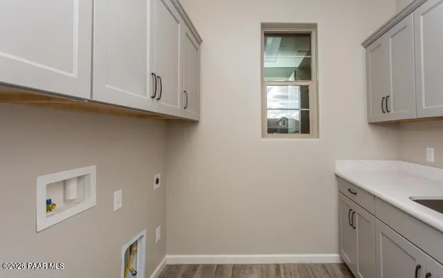 a view of cabinets and utility room with wooden floor