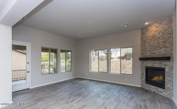 an empty room with windows and a fireplace