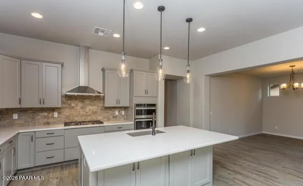 a kitchen with stainless steel appliances granite countertop a sink refrigerator and cabinets