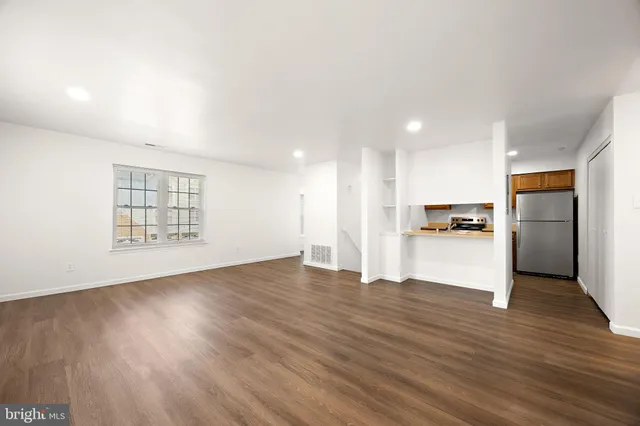 a view of kitchen with refrigerator and wooden floor