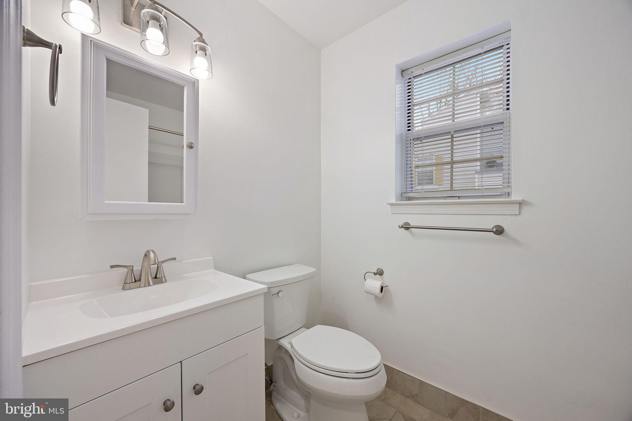 129 Emery Court, Unit A Newark, DE 19711 - Photo 7 of 15 a bathroom with a toilet sink vanity and mirror