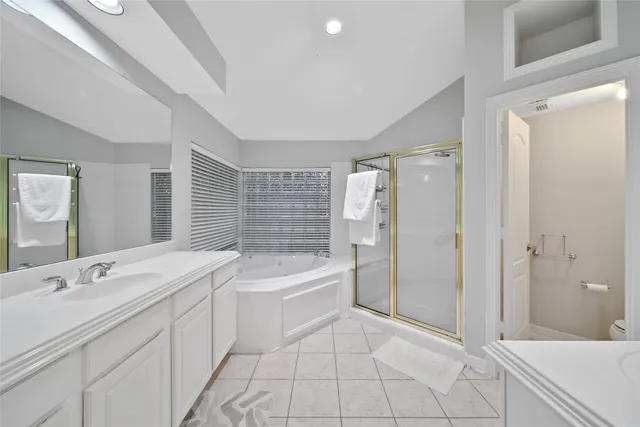 a spacious bathroom with a shower a sink and a mirror