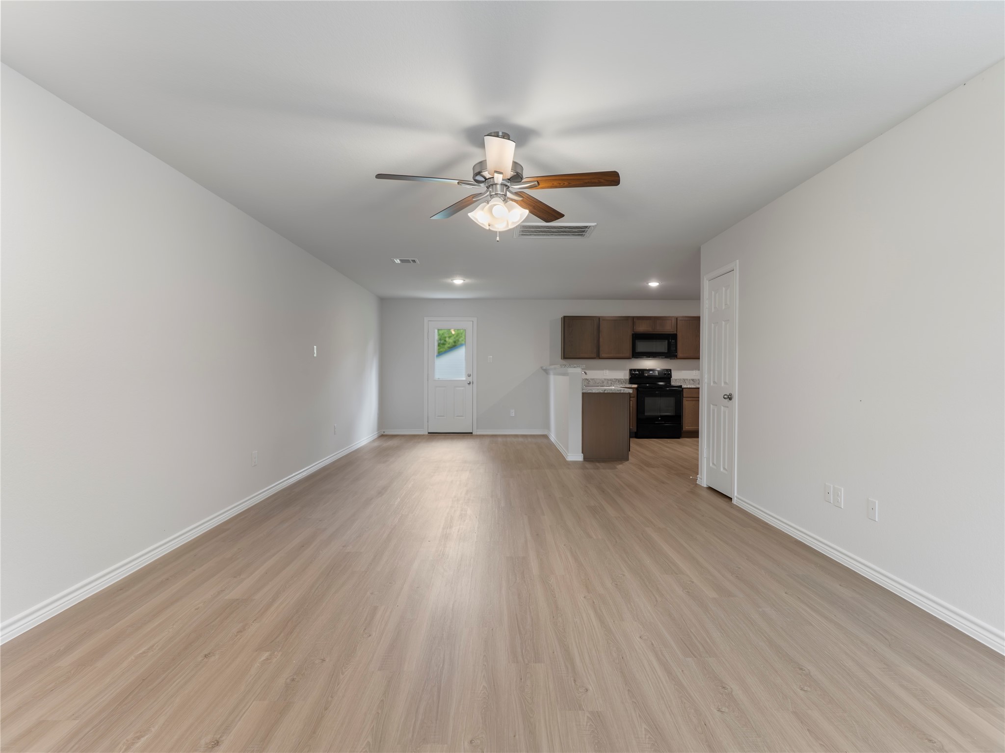 306 North Orange Street Sweeny, TX 77480 - Photo 2 of 30 a view of empty room with wooden floor and kitchen view