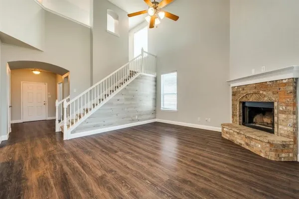 a view of an empty room wooden floor and a fireplace