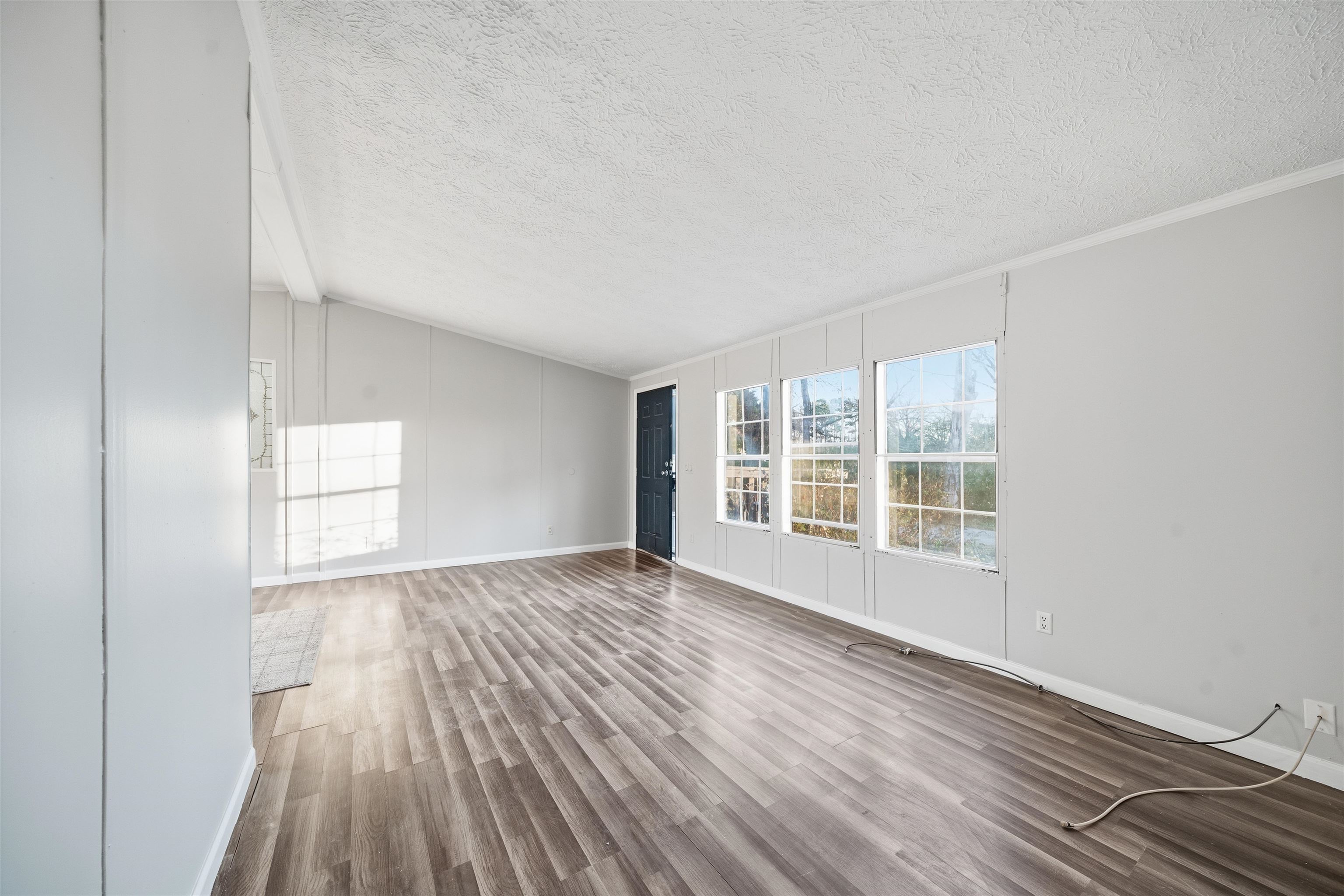 79 Stevens Road Mason, TN 38049 - Photo 5 of 21 Spare room featuring wood finished floors, a decorative wall, a textured ceiling, vaulted ceiling, and ornamental molding