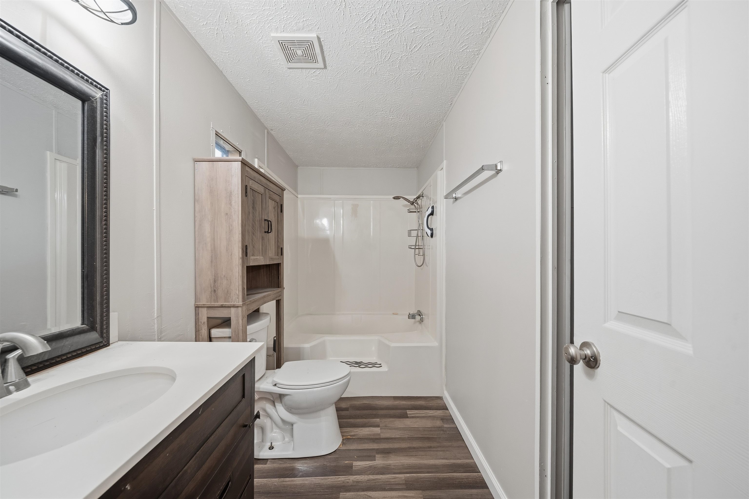 79 Stevens Road Mason, TN 38049 - Photo 10 of 21 Full bathroom featuring vanity, a textured ceiling, shower / washtub combination, and dark wood finished floors