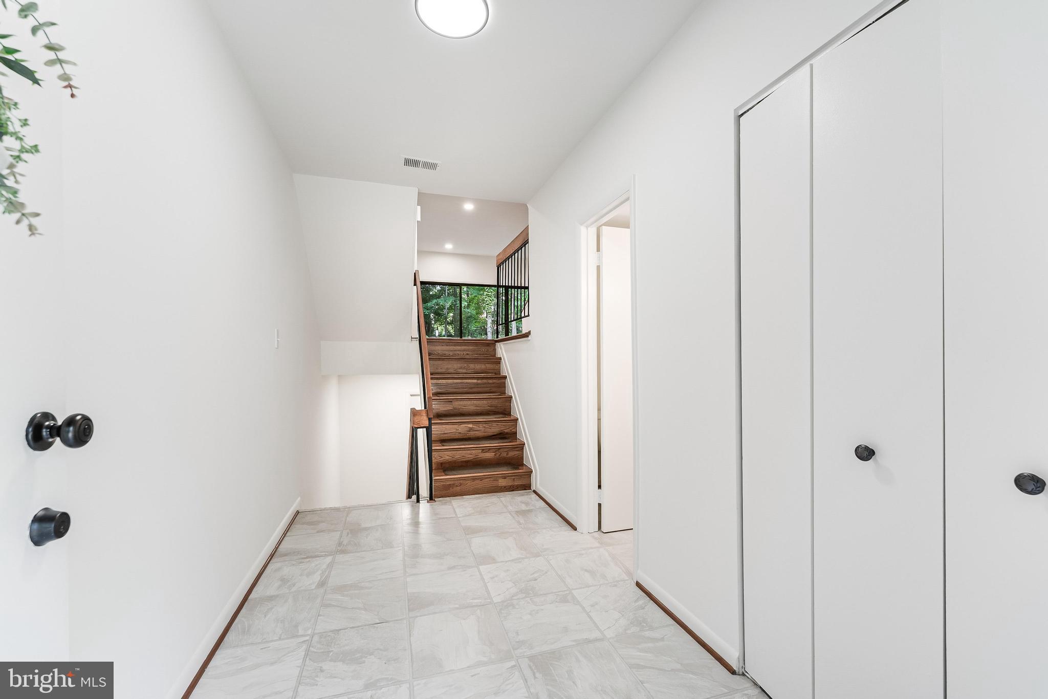 12023 Insha Court Reston, VA 20191 - Photo 3 of 52 a view of a hallway with wooden floor and staircase