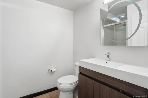 a bathroom with a sink a toilet and a mirror