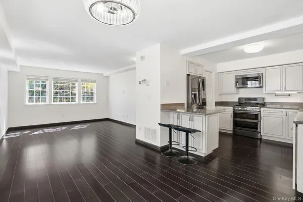 a kitchen with granite countertop a stove a sink dishwasher and a stove with wooden floor