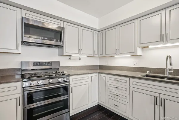 a kitchen with white cabinets and appliances