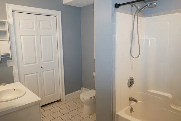 a bathroom with a shower a toilet and a sink