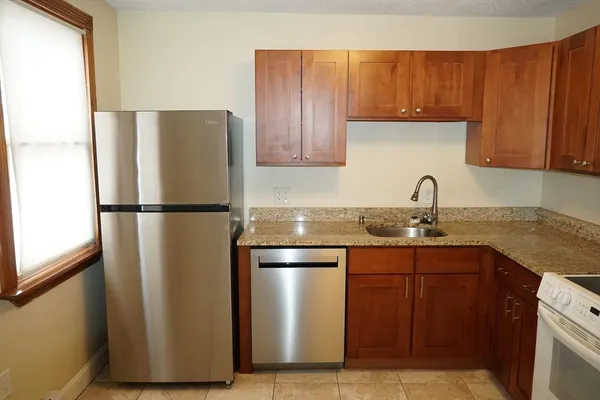 a kitchen with stainless steel appliances granite countertop a refrigerator and a sink