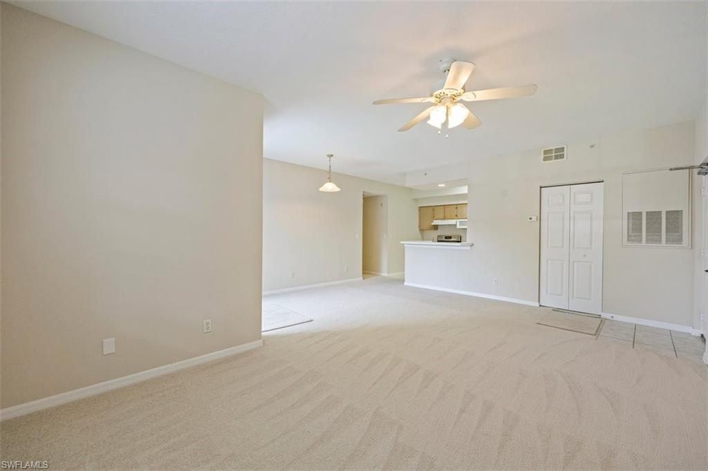 4635 St Croix Lane, Unit 1218 Naples, FL 34109 - Photo 7 of 40 Unfurnished living room featuring light carpet and a ceiling fan
