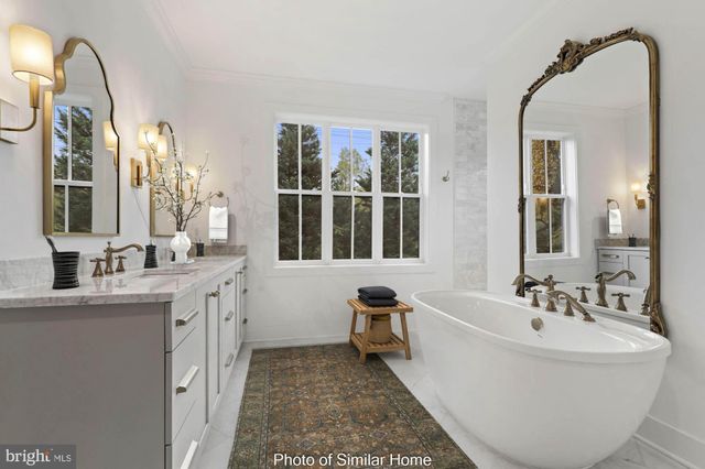 a spacious bathroom with a double vanity sink a mirror and a bathtub