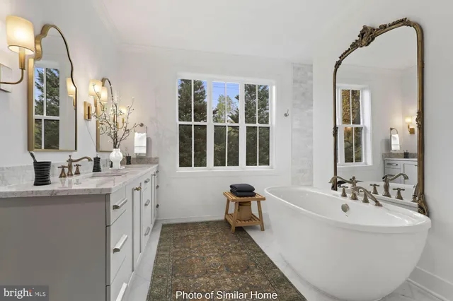 a spacious bathroom with a double vanity sink a mirror and a bathtub