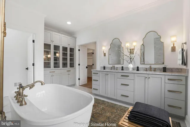 a spacious bathroom with a double vanity sink a mirror and a bathtub