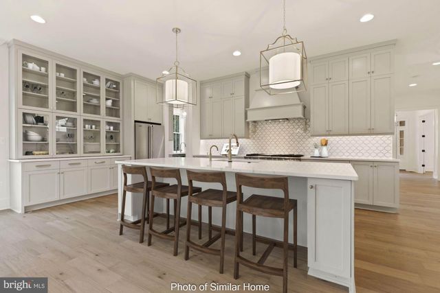 a kitchen with cabinets table and chairs