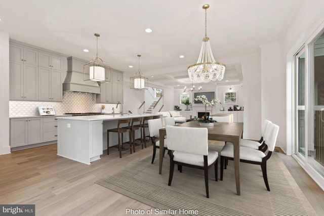 a dining room filled a chandelier and kitchen view