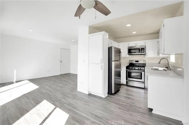 a kitchen with granite countertop a refrigerator and a stove top oven