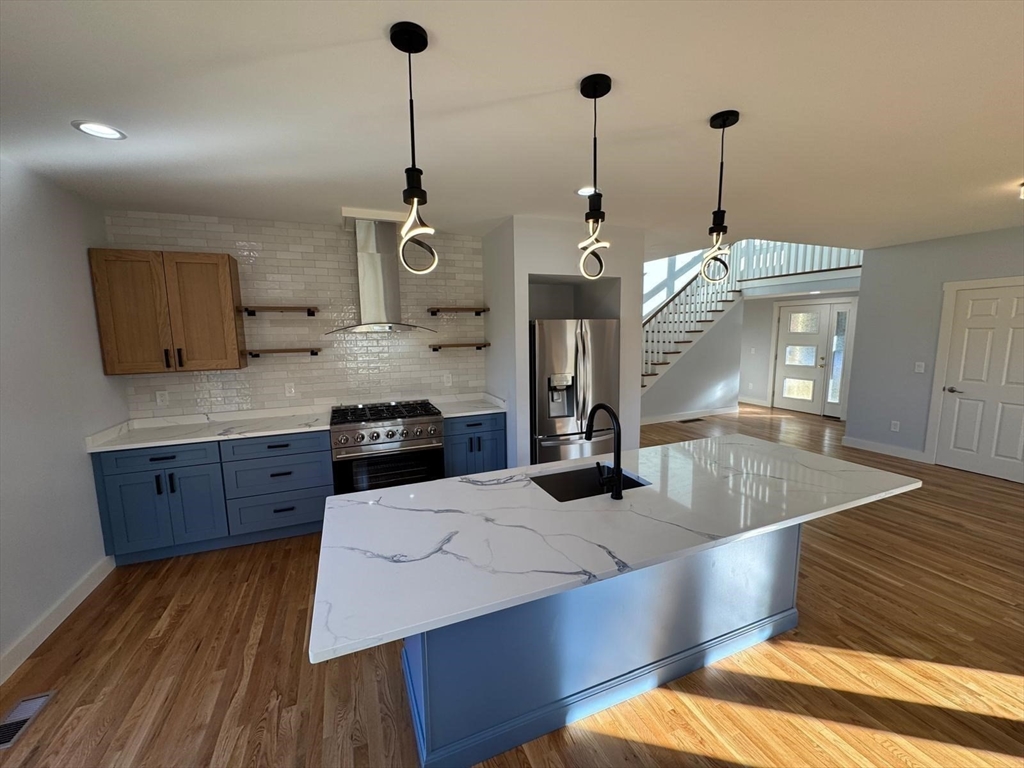 41 Westminster Street Worcester, MA 01605 - Photo 11 of 36 a kitchen with stainless steel appliances kitchen island granite countertop a sink a stove and a wooden floors