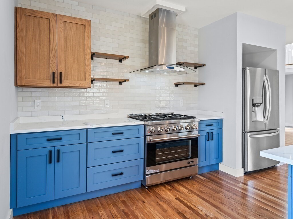 41 Westminster Street Worcester, MA 01605 - Photo 13 of 36 a kitchen with stainless steel appliances granite countertop a stove and a refrigerator with wooden cabinets