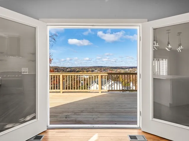 a view of balcony with floor to ceiling windows and wooden floor