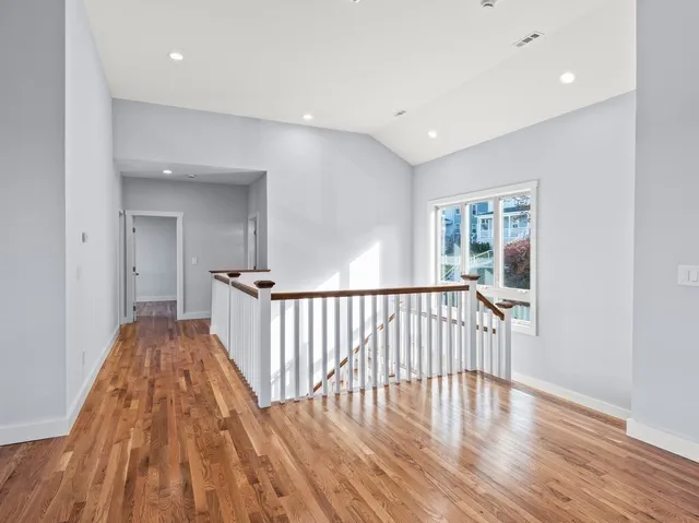 a view of a hallway with wooden floor and staircase