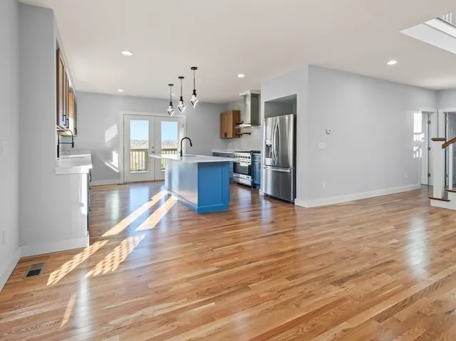 a kitchen with stainless steel appliances kitchen island granite countertop a refrigerator and a stove top oven