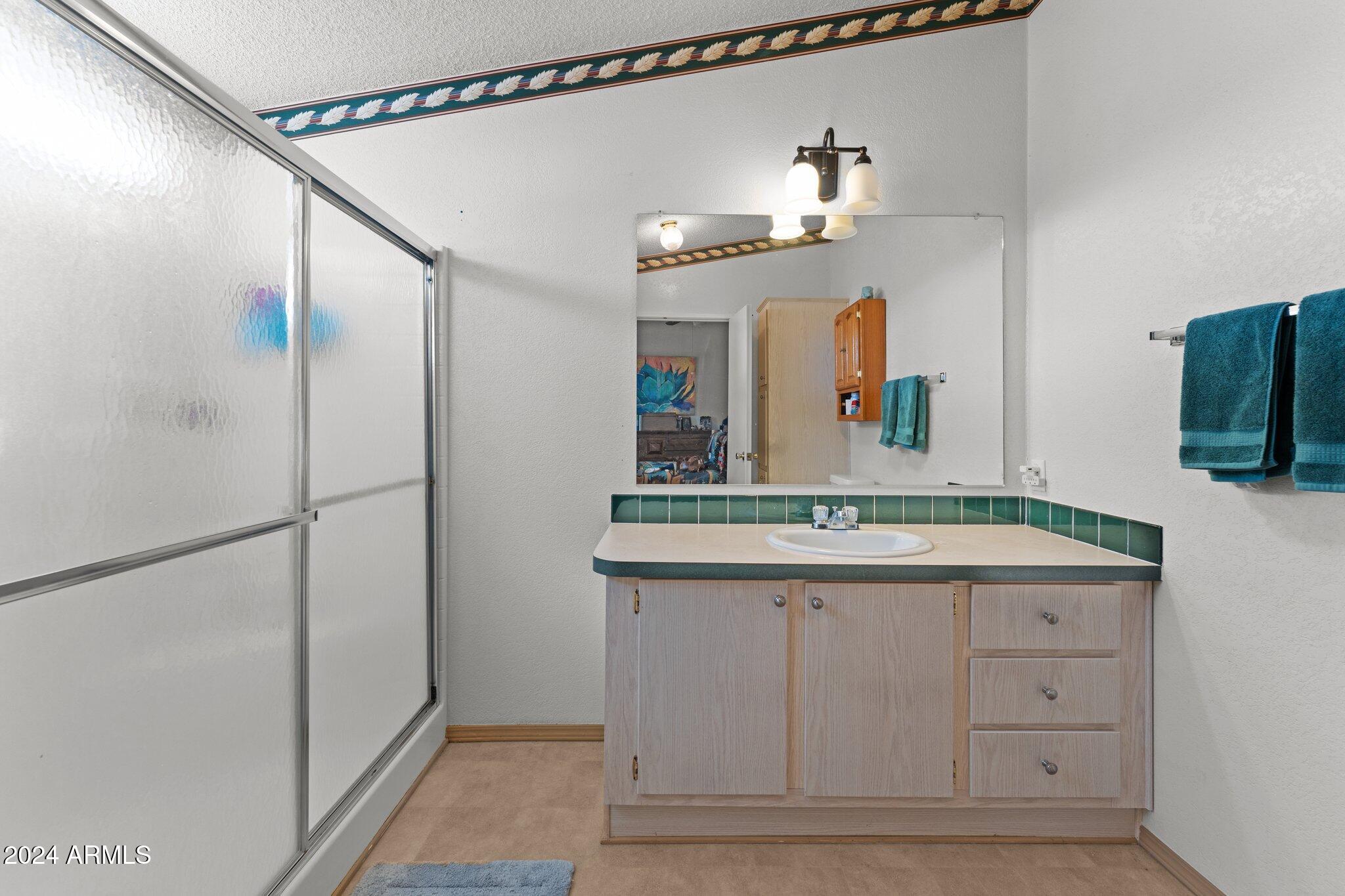 30854 Wandering Way Congress, AZ 85332 - Photo 12 of 43 a bathroom with a granite countertop sink and a mirror