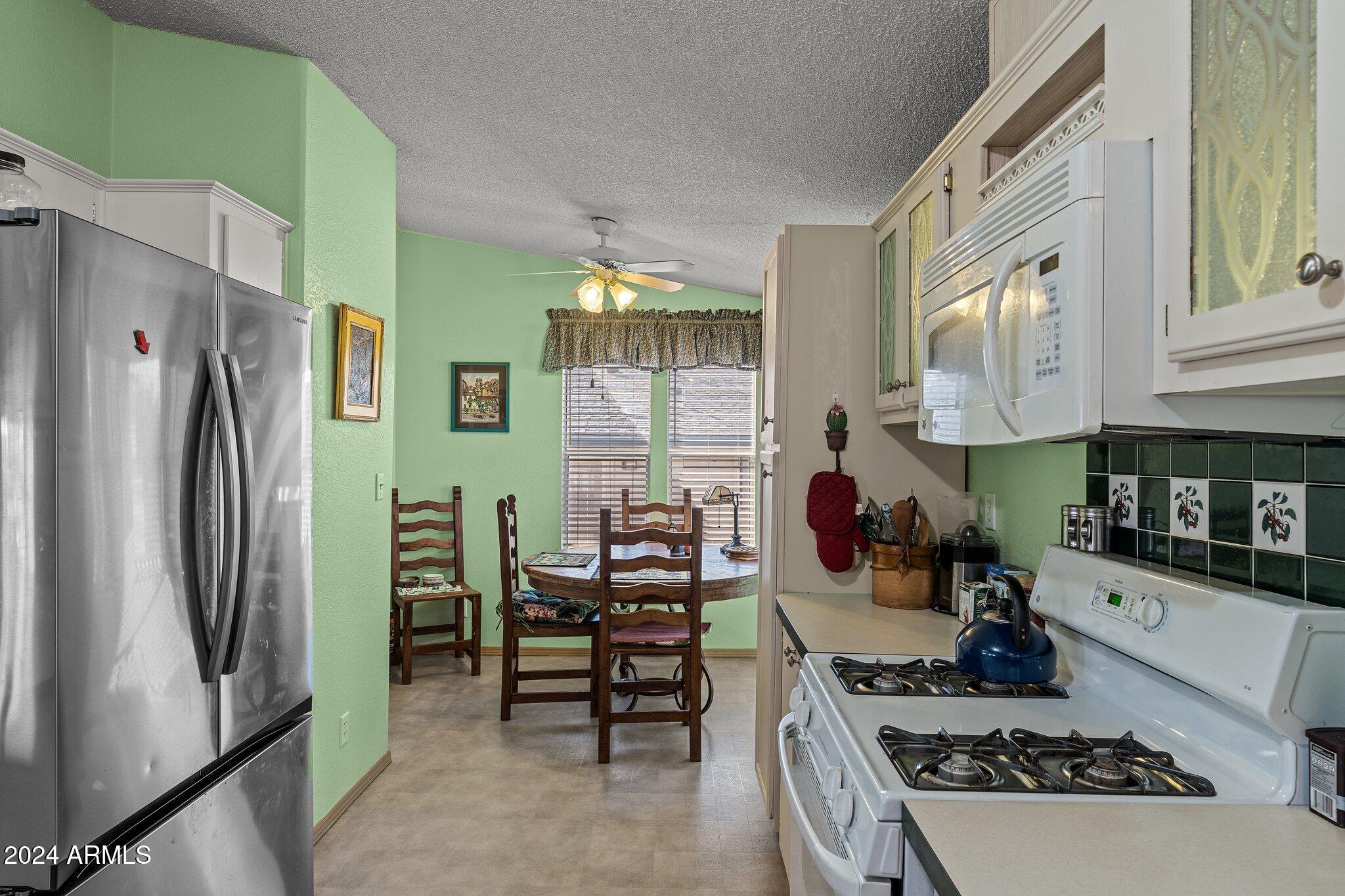 30854 Wandering Way Congress, AZ 85332 - Photo 19 of 43 a kitchen with stainless steel appliances granite countertop a stove and a refrigerator