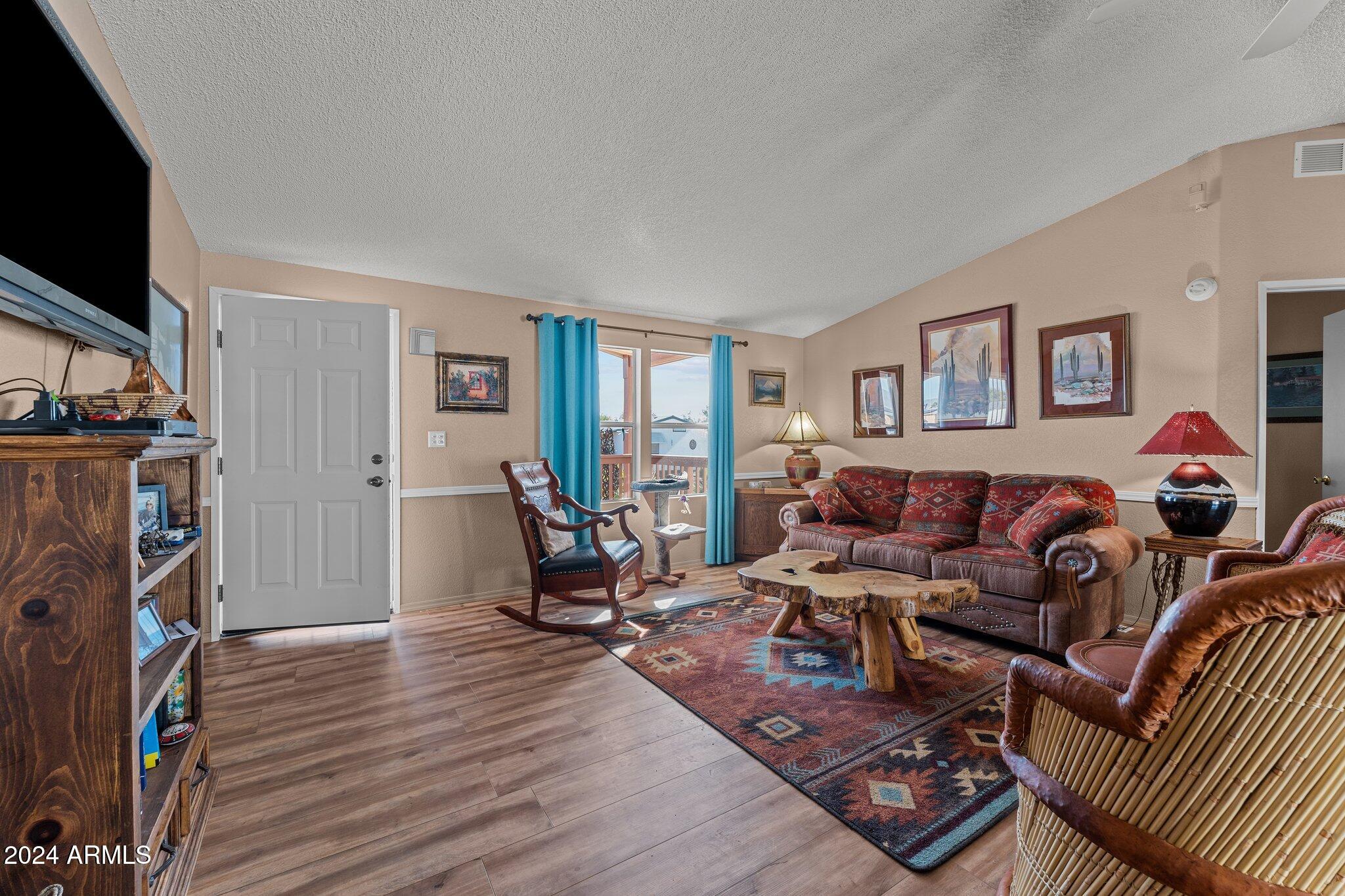 30854 Wandering Way Congress, AZ 85332 - Photo 7 of 43 a living room with furniture a flat screen tv and a fireplace