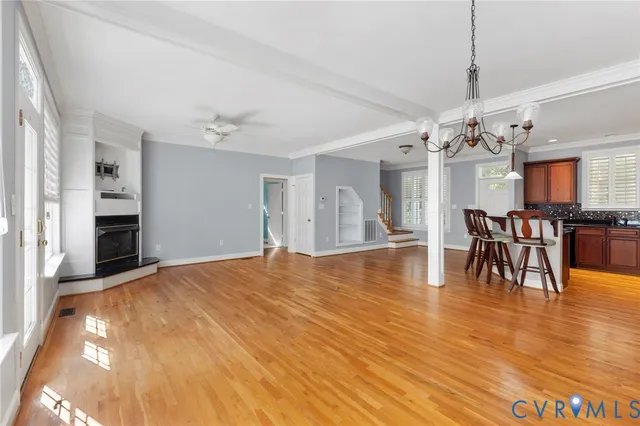 an empty room with wooden floor and fan