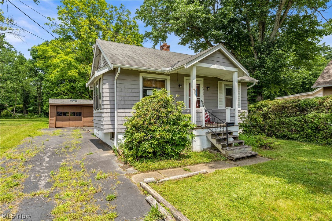 4533 Liberty Road Cleveland, OH 44121 - Photo 2 of 17 Bungalow-style home with a garage, a front lawn, covered porch, and an outdoor structure