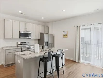 a kitchen with a sink a microwave a refrigerator and cabinets