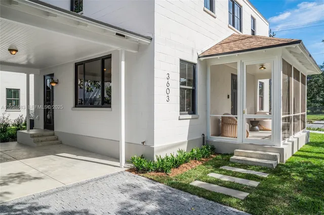 a view of a house with many windows and plants