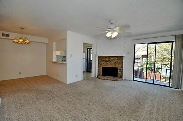 a view of a livingroom with an empty room and chandelier fan