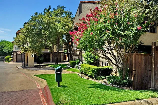 a front view of a house with a yard and a fountain
