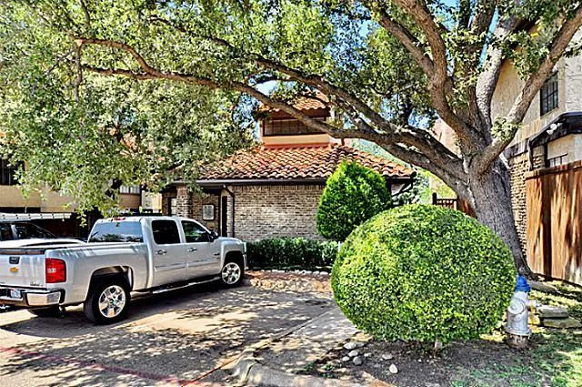 a front view of a house with a tree