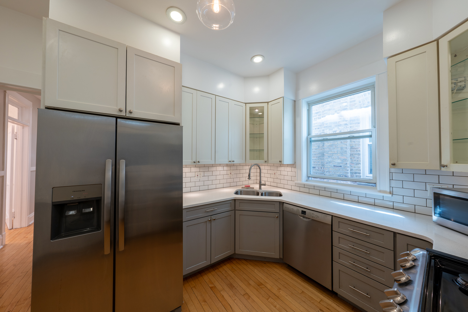 1460 West Foster Avenue, Unit 1 Chicago, IL 60640 - Photo 12 of 14 a kitchen with a sink a refrigerator and window