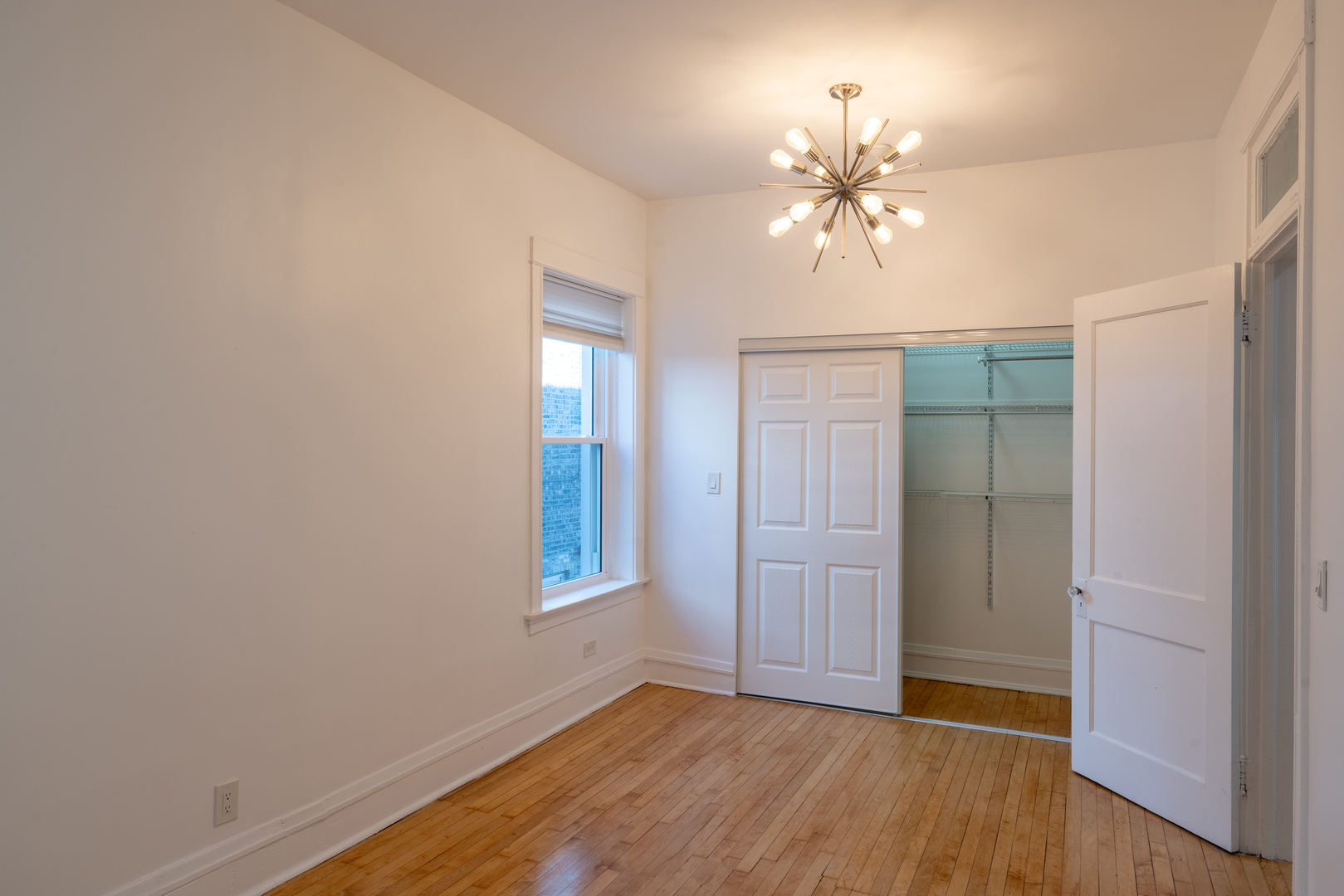 1460 West Foster Avenue, Unit 1 Chicago, IL 60640 - Photo 7 of 14 wooden floor in an empty room with a window