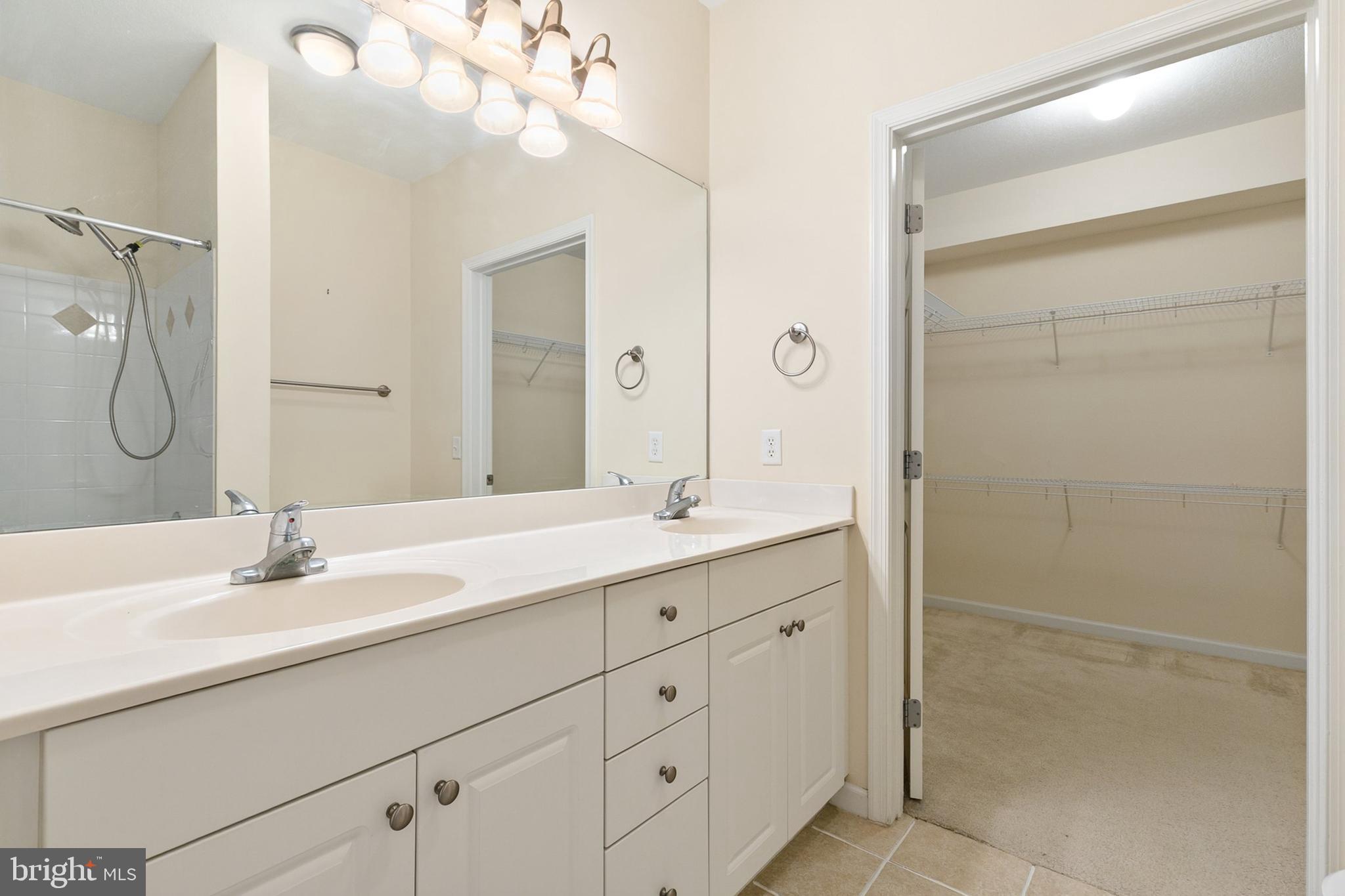 7 Granite Place, Unit 316 Gaithersburg, MD 20878 - Photo 19 of 84 a bathroom with a double vanity sink mirror and shower