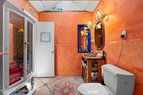 a bathroom with a toilet a sink and mirror